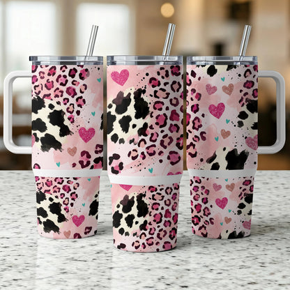 Three pink leopard print tumblers with pink and blue hearts and handles.
