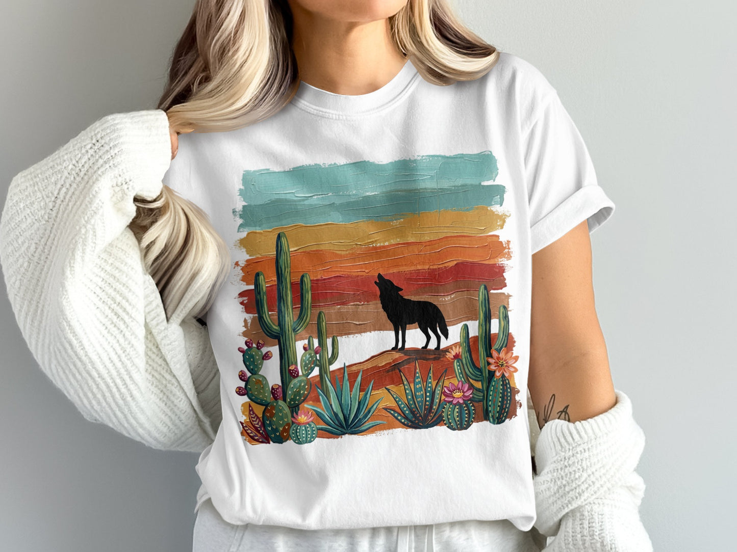 White t-shirt with howling wolf, cacti, and desert sunset illustration.