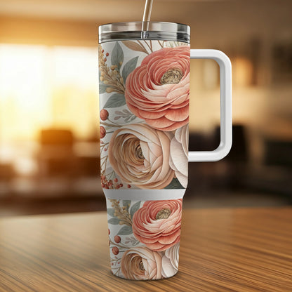 Floral patterned tumbler with handle and straw on a wooden surface.