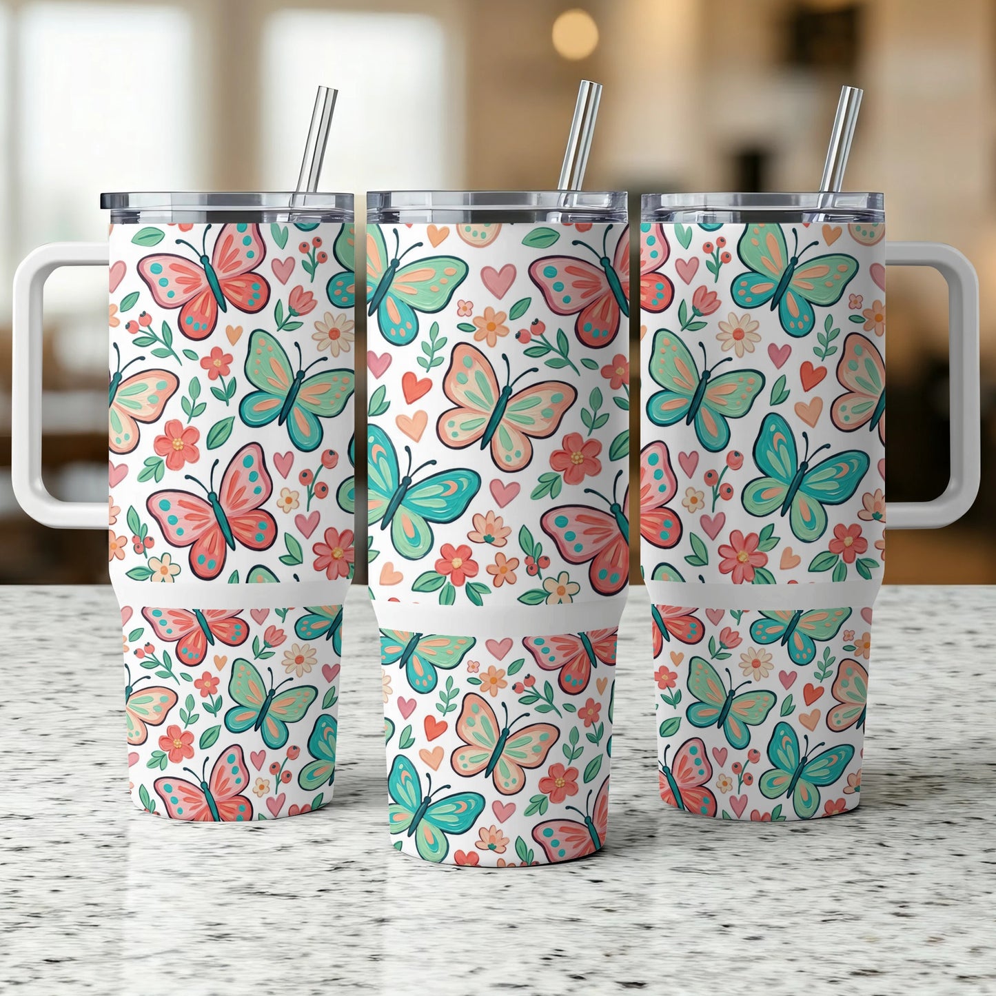 Three tumblers with colorful butterfly and flower patterns and reusable straws.