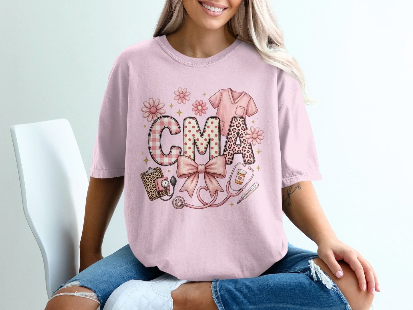 Pink t-shirt with "CMA" in patterned letters, stethoscope, and nurse scrub top.