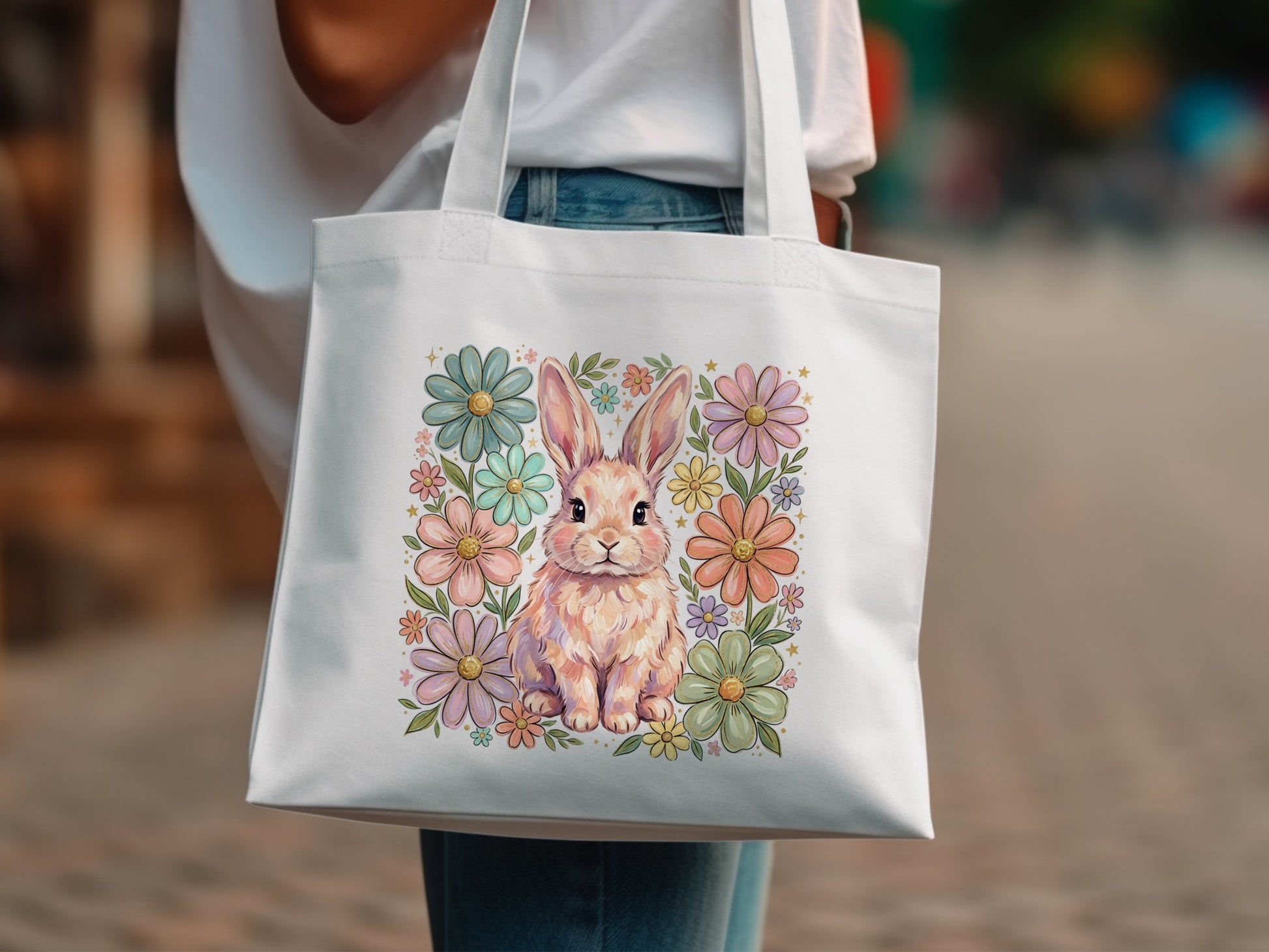 White tote bag with a pastel bunny surrounded by floral art.