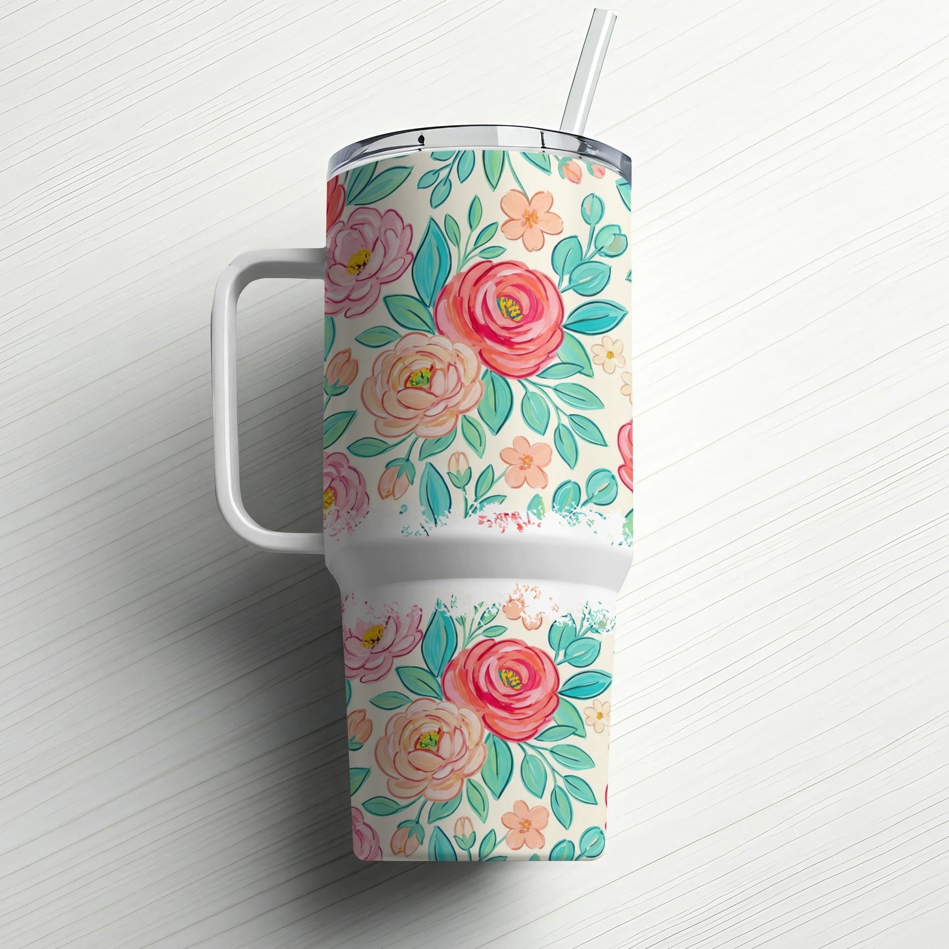 Floral patterned tumbler with handle and straw.