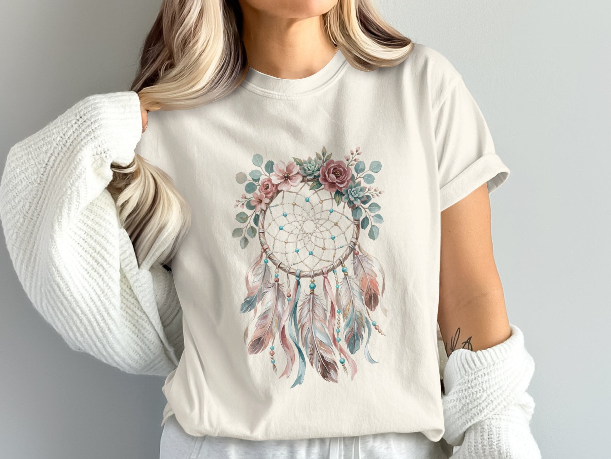 Cream t-shirt featuring a dreamcatcher with feathers and floral accents.