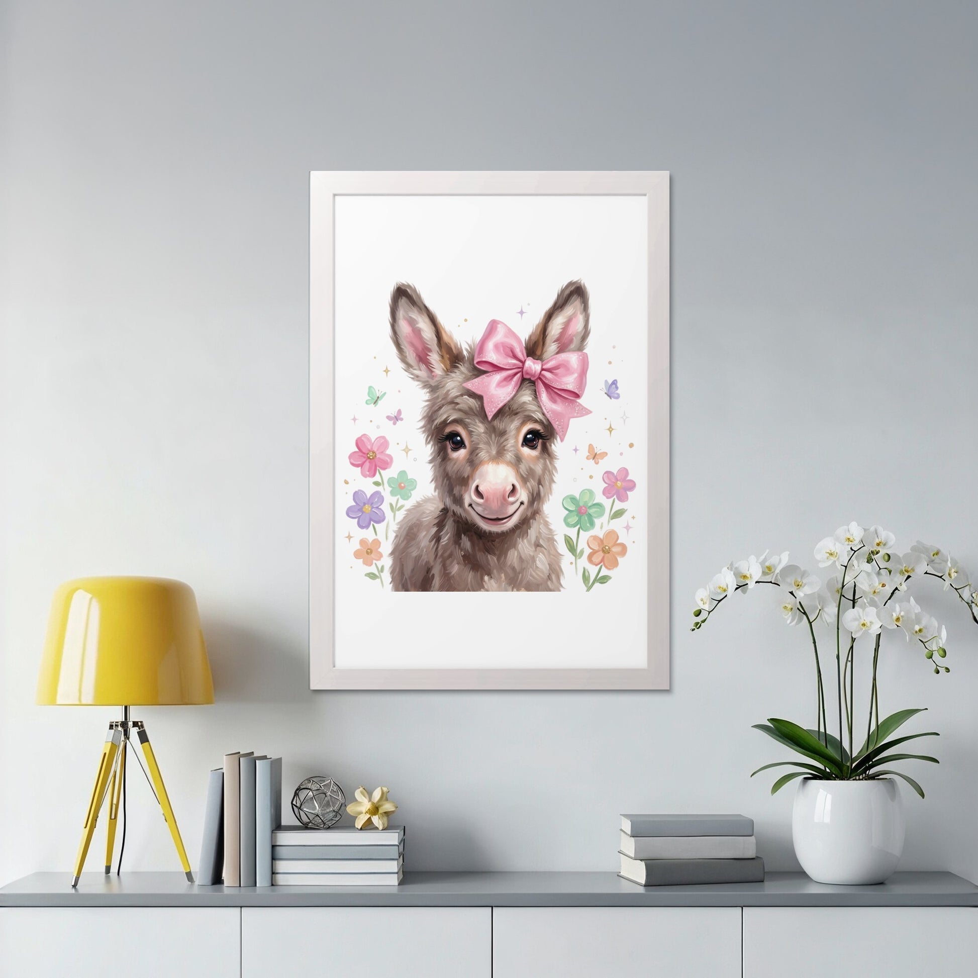 Framed artwork of a smiling donkey with a pink bow and flowers.