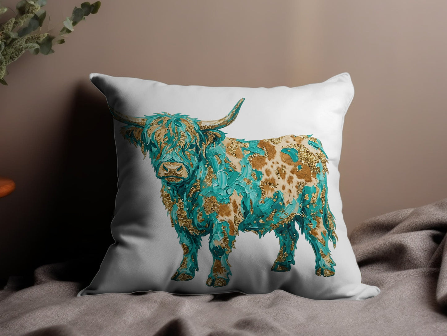 Highland cow with turquoise and gold abstract design on white pillow.