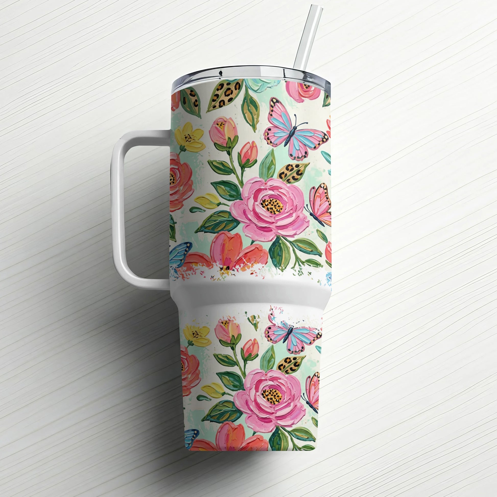 Floral tumbler with handle and straw, featuring pink roses and blue butterflies.