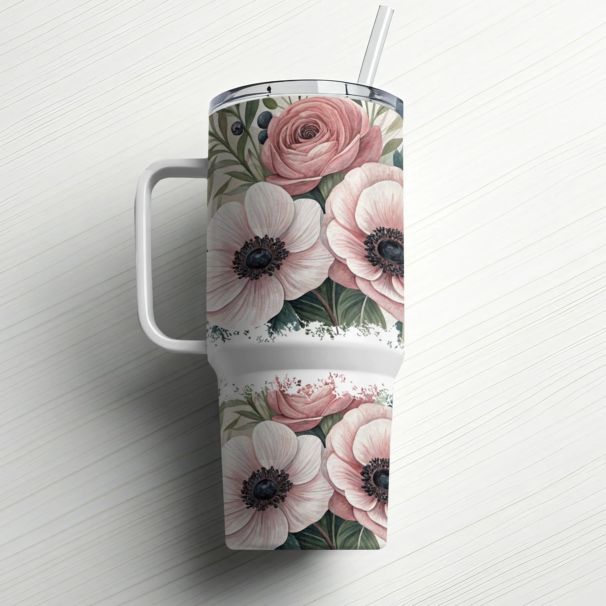 White tumbler with pink flowers and green leaves, white handle and straw.
