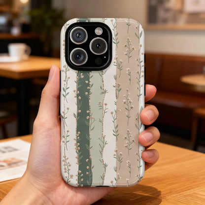 Hand holding a phone case with a floral stripe pattern in green and beige.