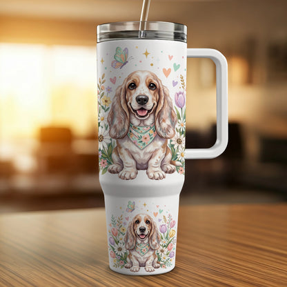 Basset Hound illustration on a white tumbler with floral and butterfly accents.