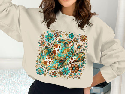 Cowboy hat graphic with floral and glitter accents on a cream sweatshirt.