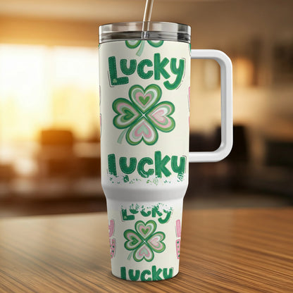 White tumbler with green clover and "lucky" pattern, for hot or cold drinks.
