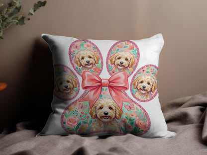 Pillow with a large paw print filled with doodle dog portraits and a pink bow.