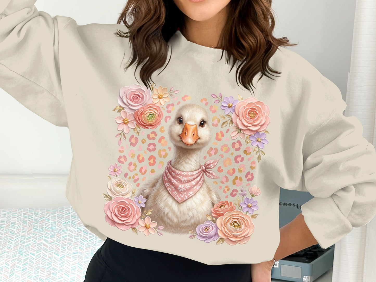 Cream sweatshirt with a cute goose wearing a pink bandana surrounded by flowers.