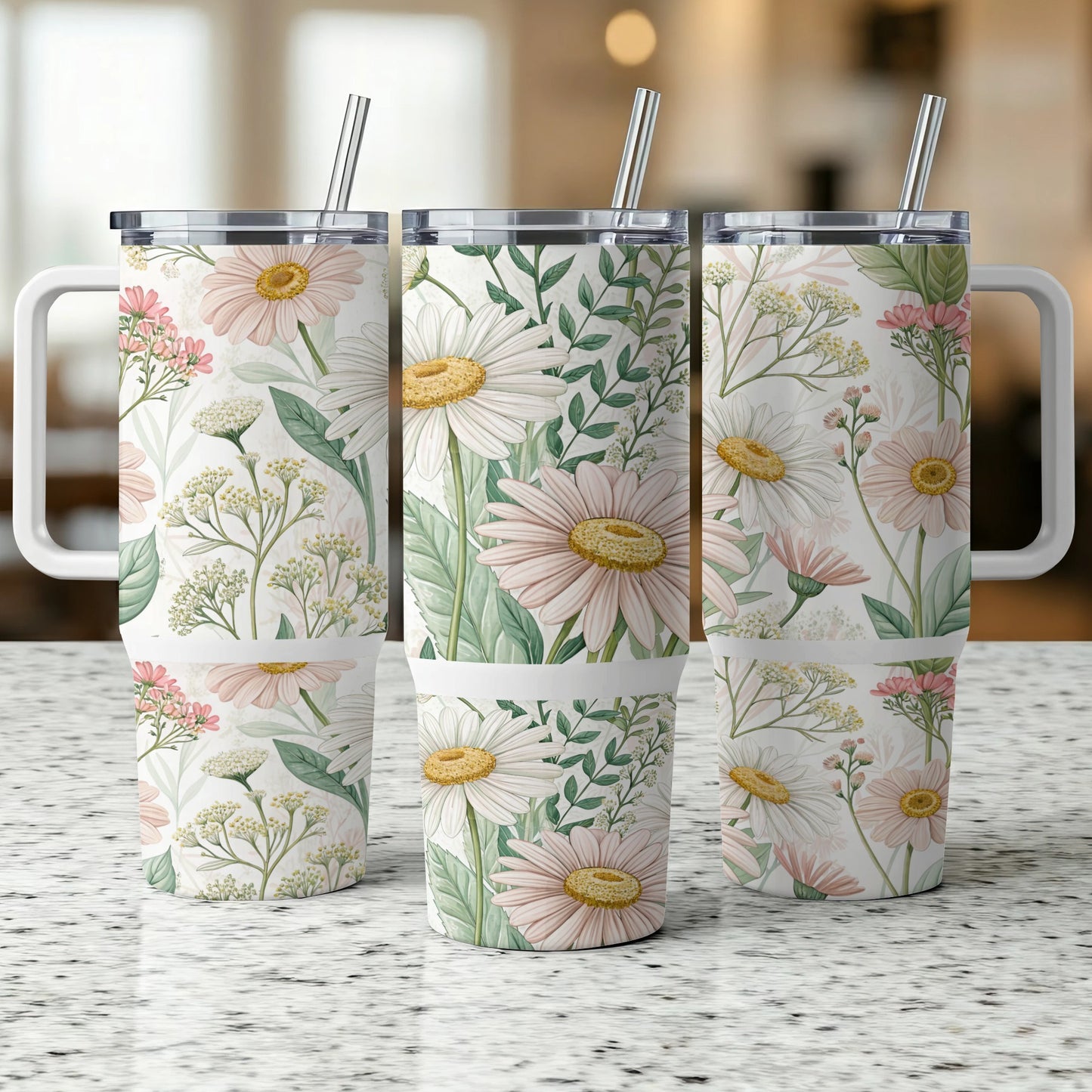 Three floral tumblers with daisies and greenery, displayed on a speckled countertop.
