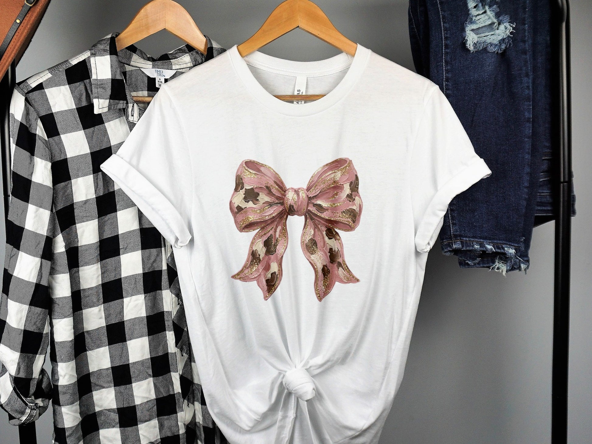 White t-shirt with a gold and pink sparkly bow design.
