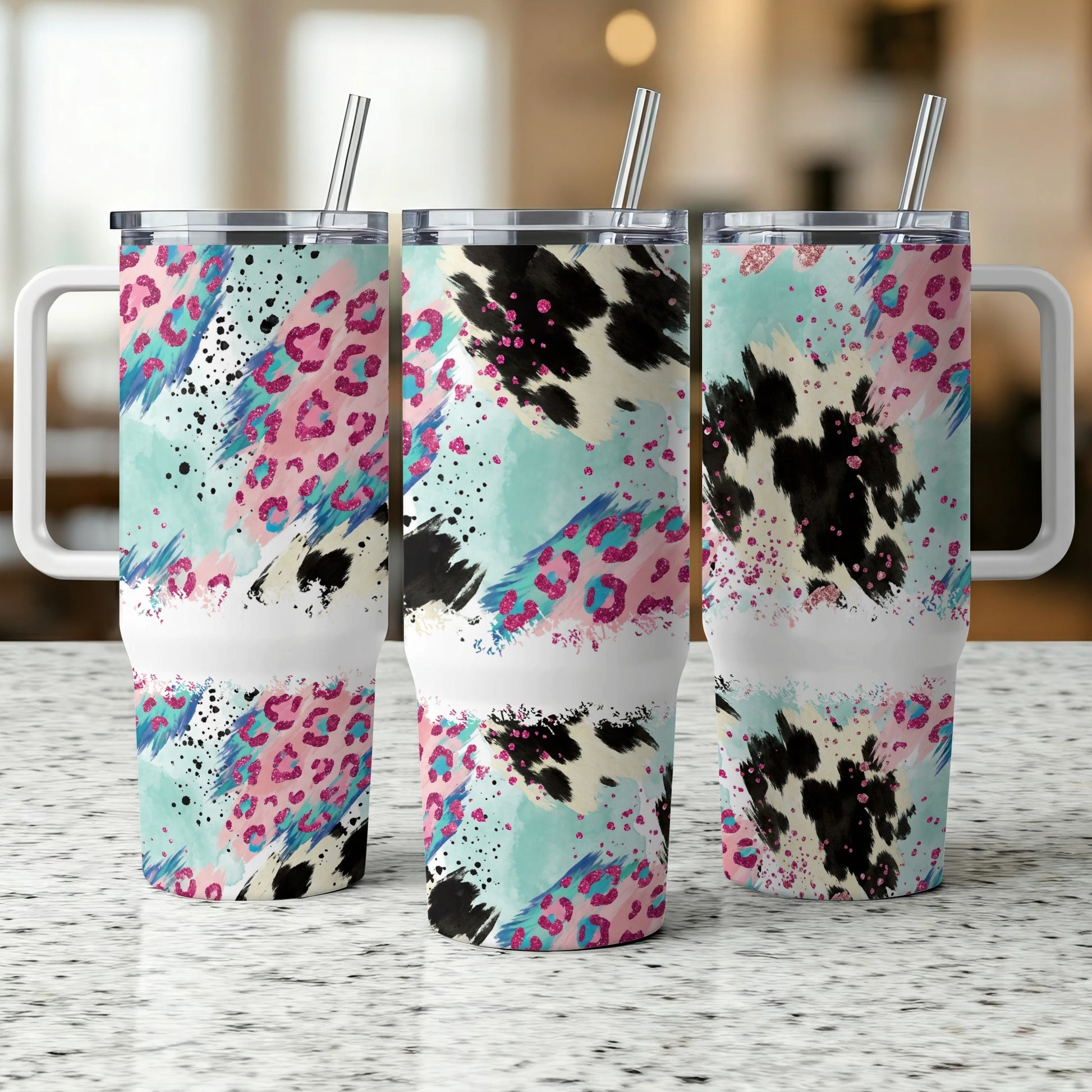 Three tumblers with abstract leopard and cow print patterns.
