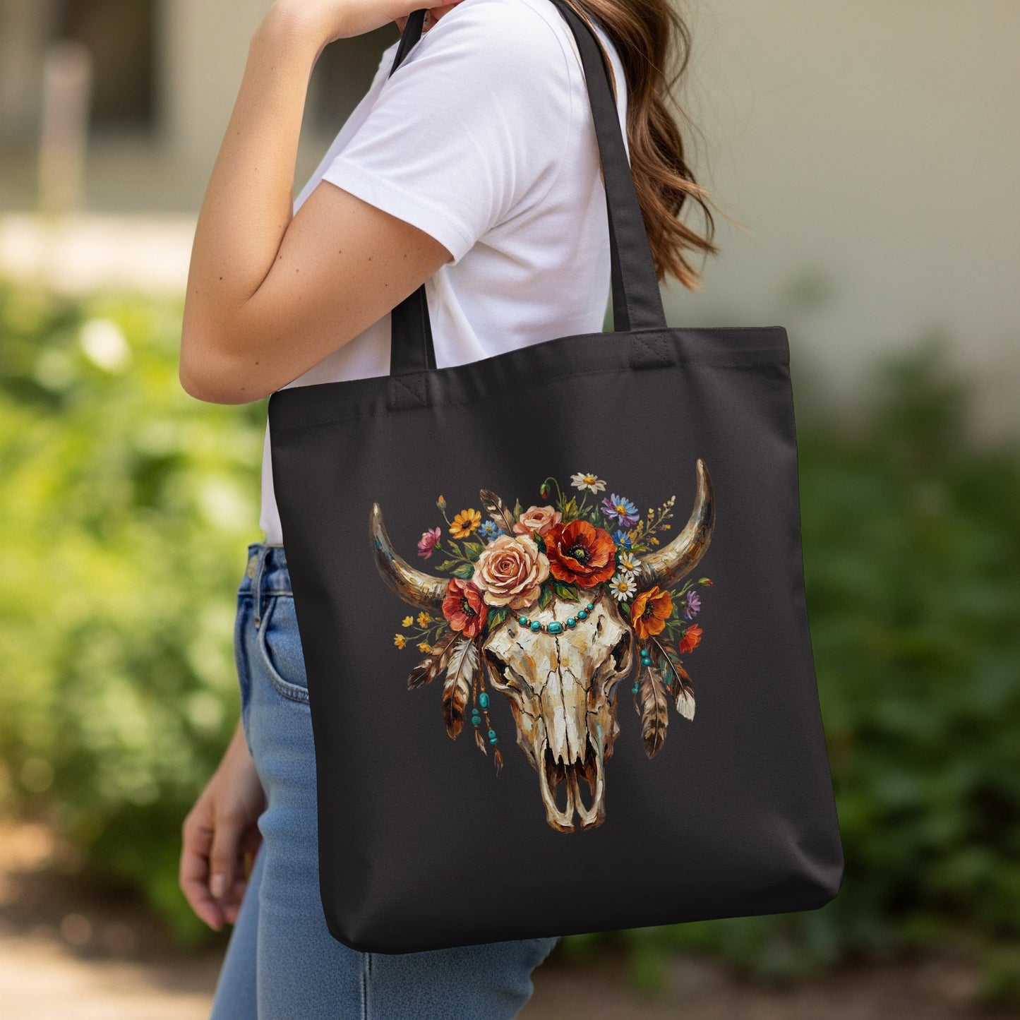 Black tote bag with a detailed bull skull and floral wreath design.
