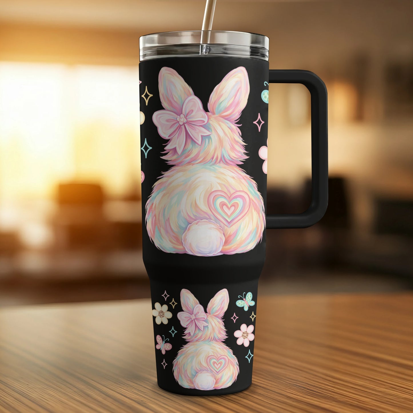 Black tumbler with pastel rainbow bunny, flowers, and butterflies.