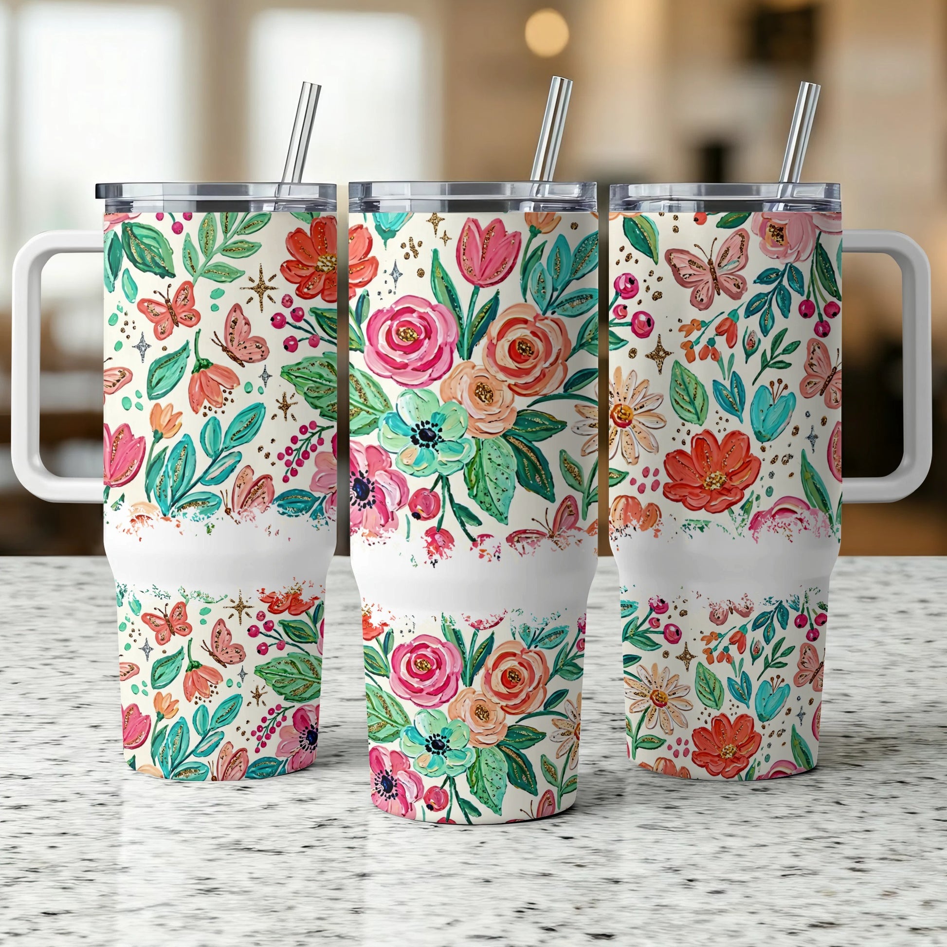Three tumblers with floral and butterfly designs on a speckled countertop.