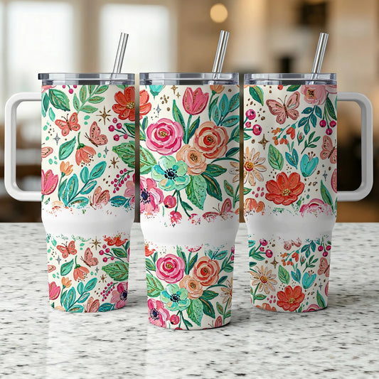 Three tumblers with floral and butterfly designs on a speckled countertop.
