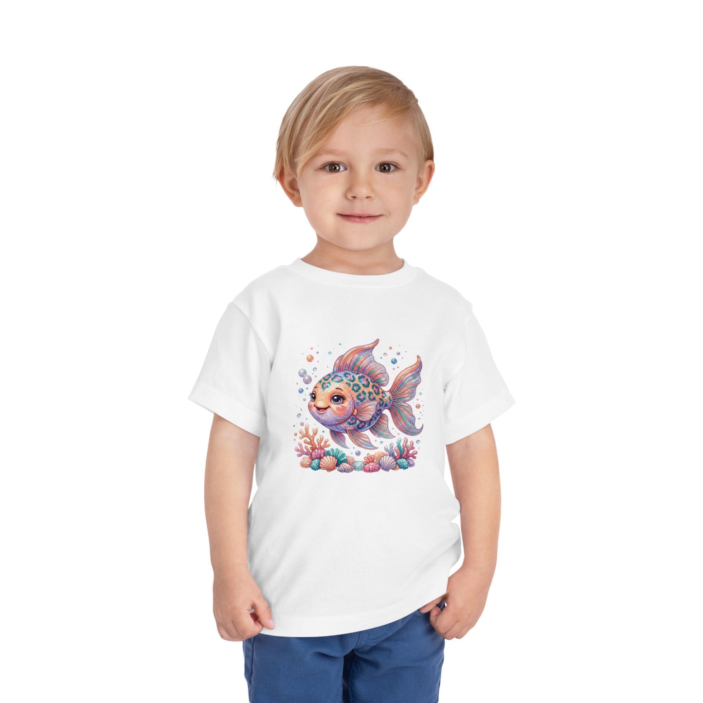 Young child wearing a white t-shirt with a colorful cartoon fish and coral graphic.