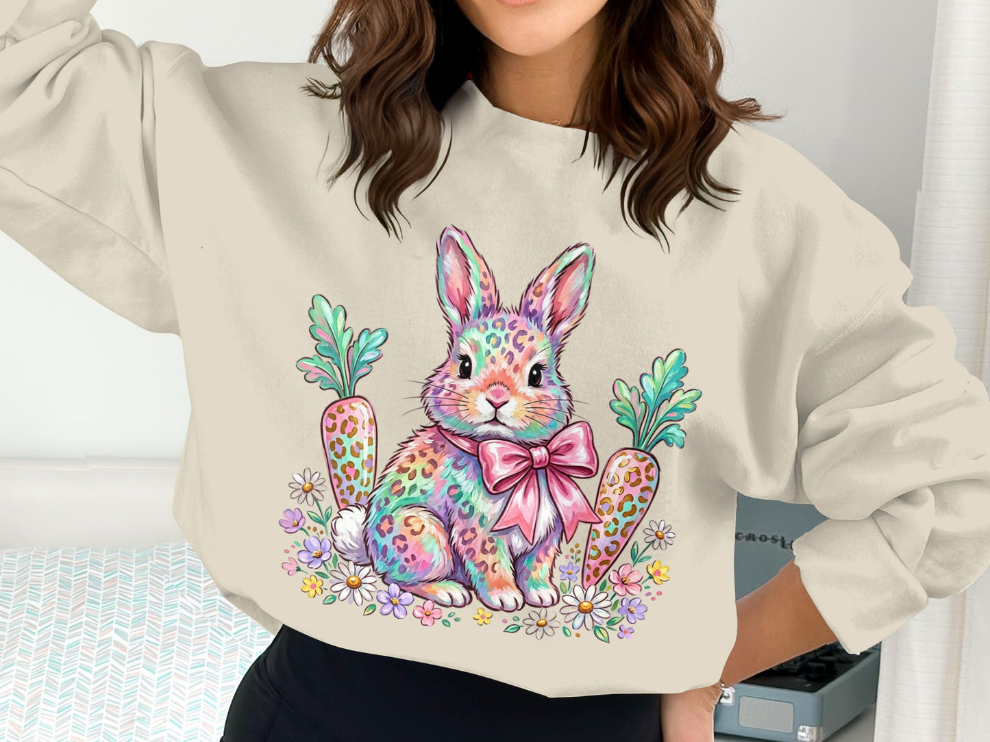 Leopard print Easter bunny with pink bow sits among carrots and flowers.