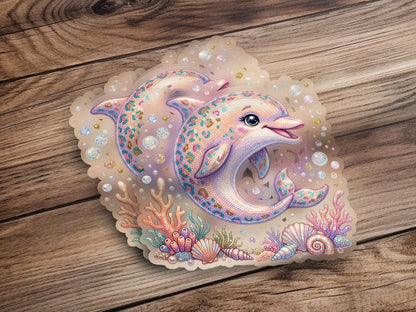 Two cute dolphins surrounded by shells and coral on a wooden background.