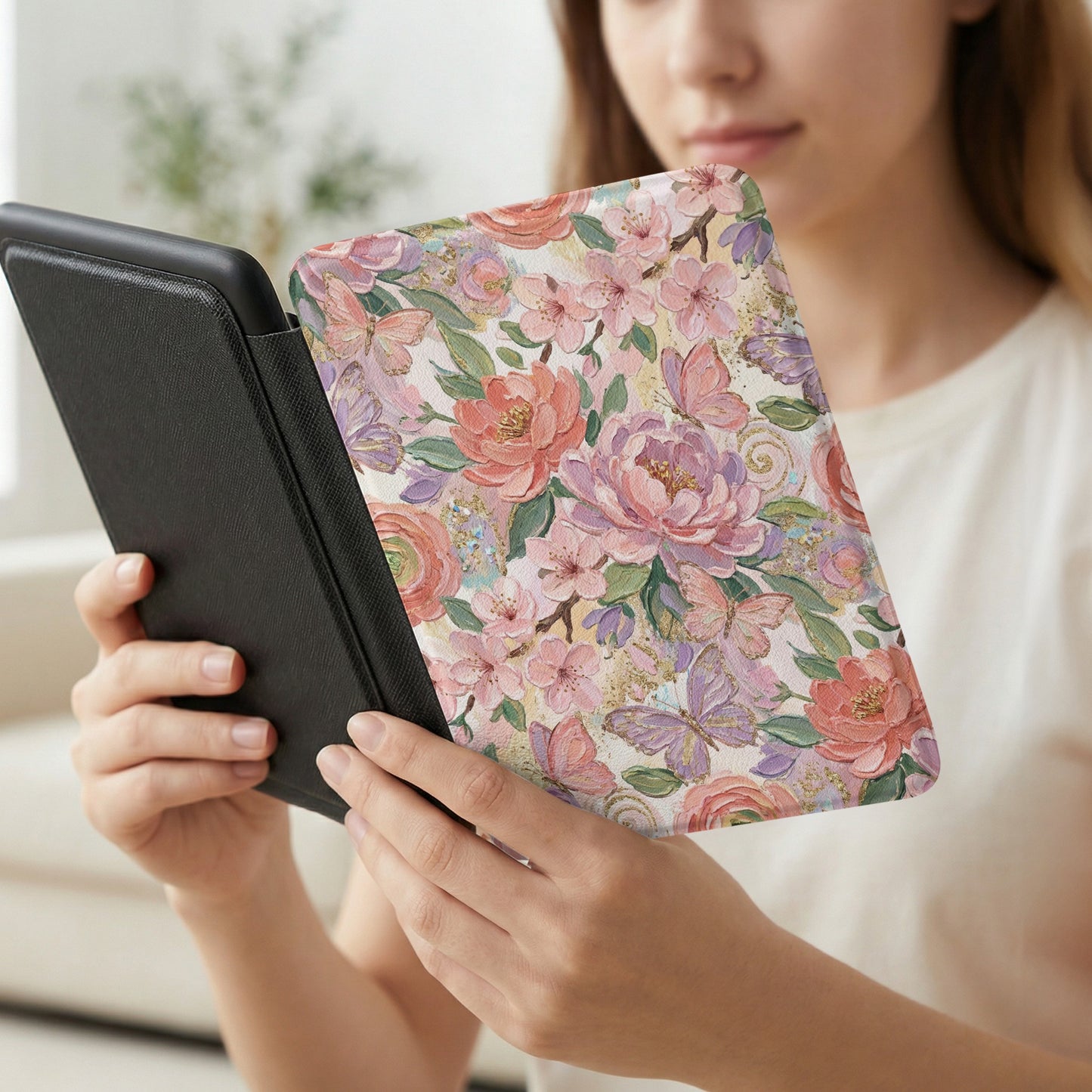 Woman holding a floral patterned e-reader cover with butterflies.