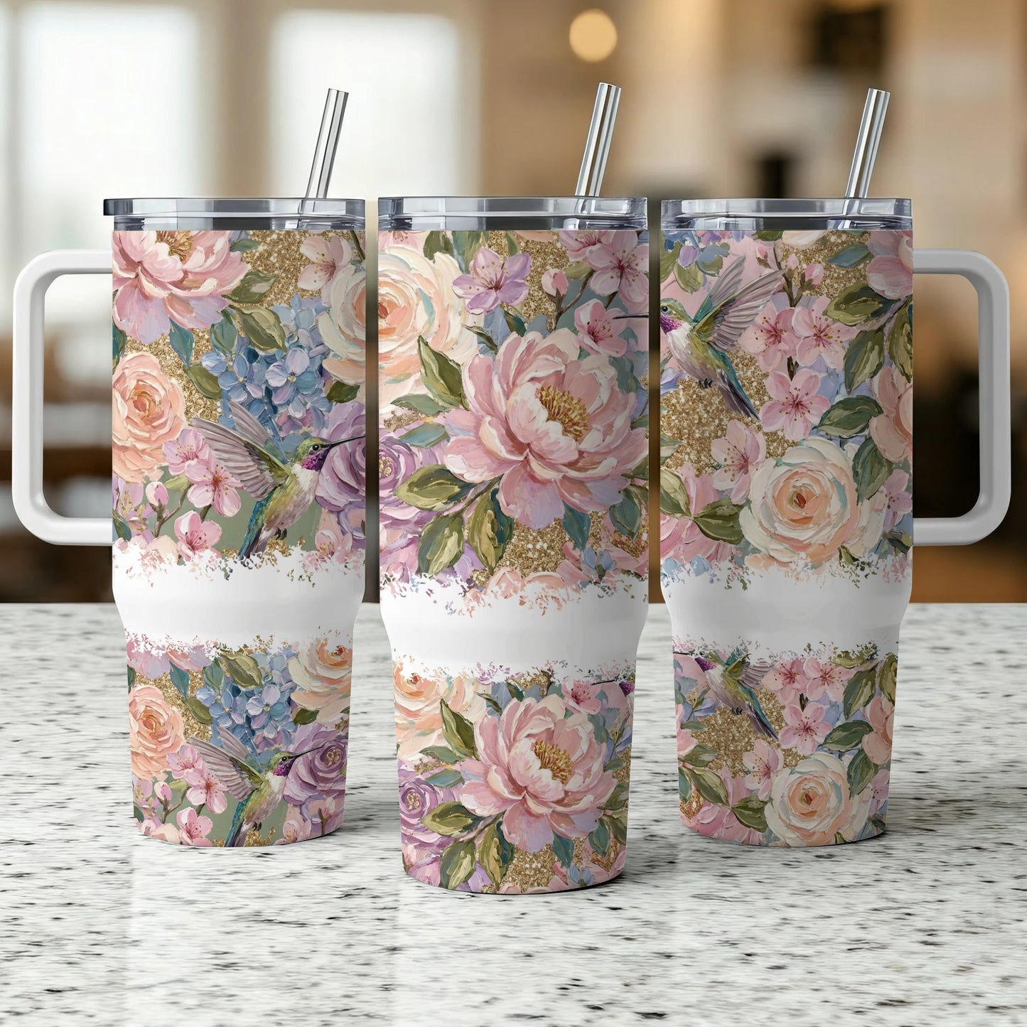 Three tumblers with floral and hummingbird designs, side by side.
