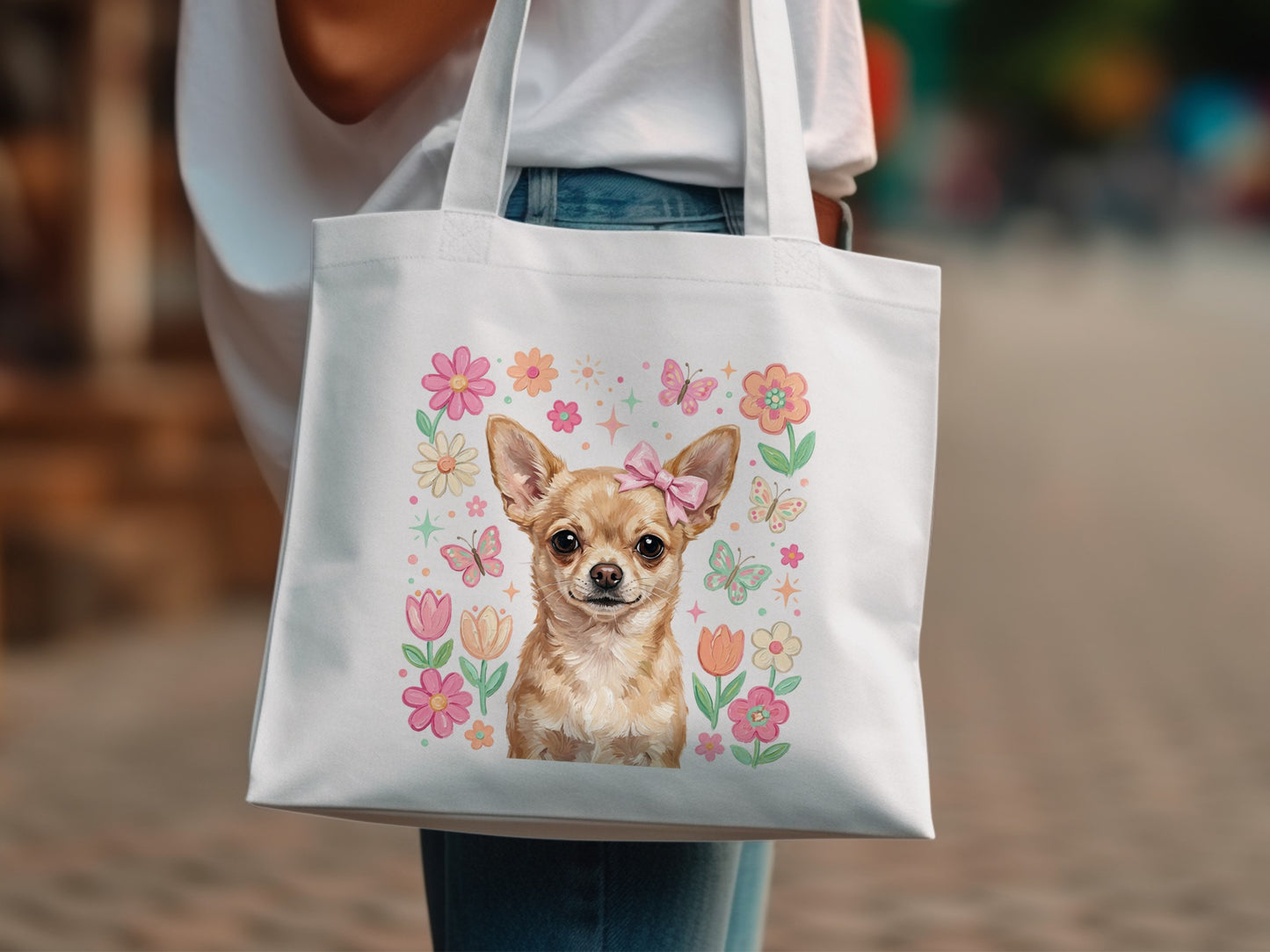 Chihuahua with butterflies and flowers graphic on a white tote bag.