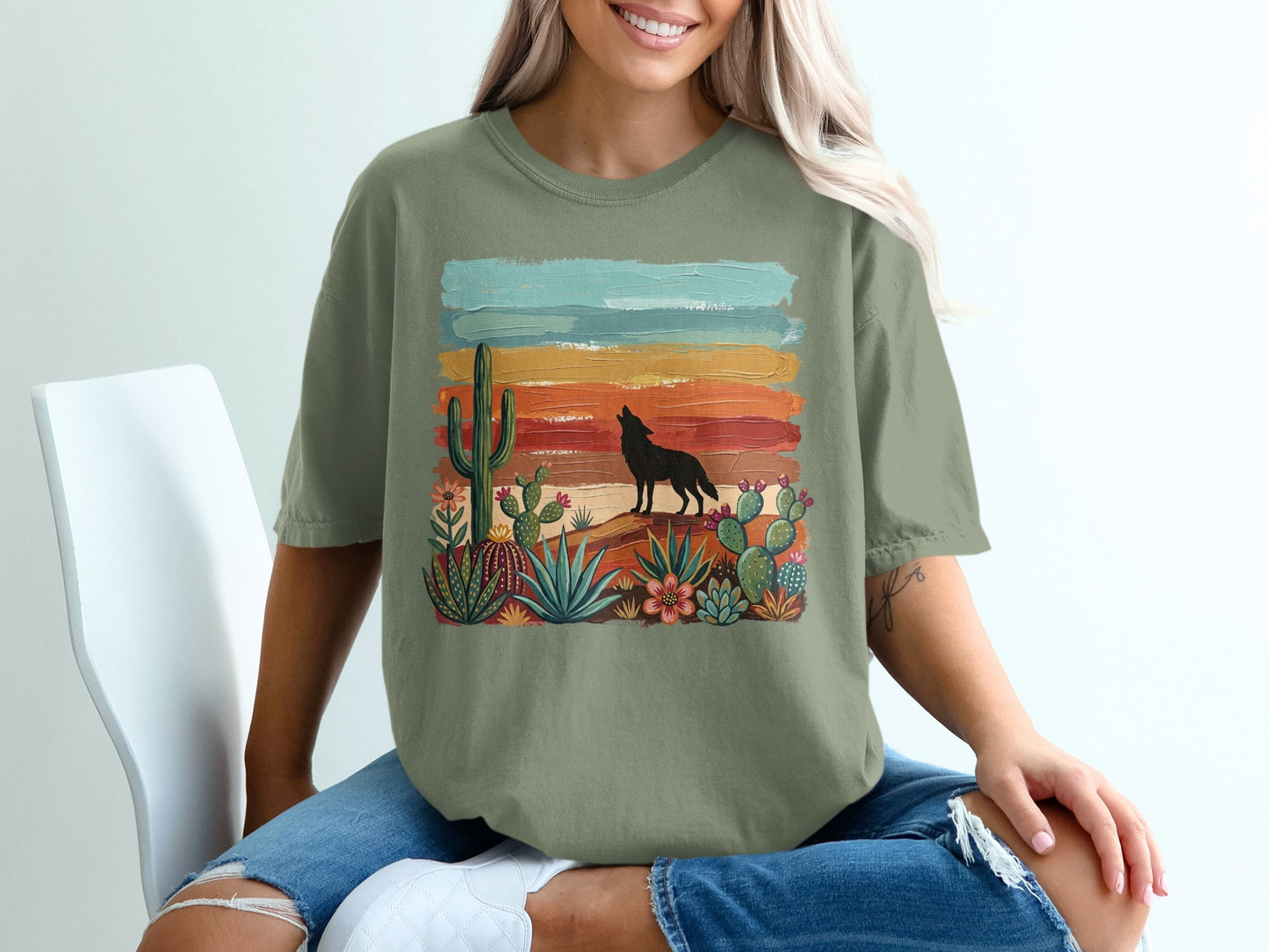 Green t-shirt with desert landscape and howling wolf graphic.