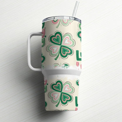 Cream tumbler with shamrock pattern and handle, straw in lid.