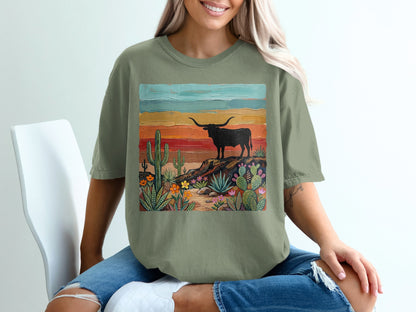 T-shirt with desert landscape, longhorn steer, cacti, and colorful sunset.