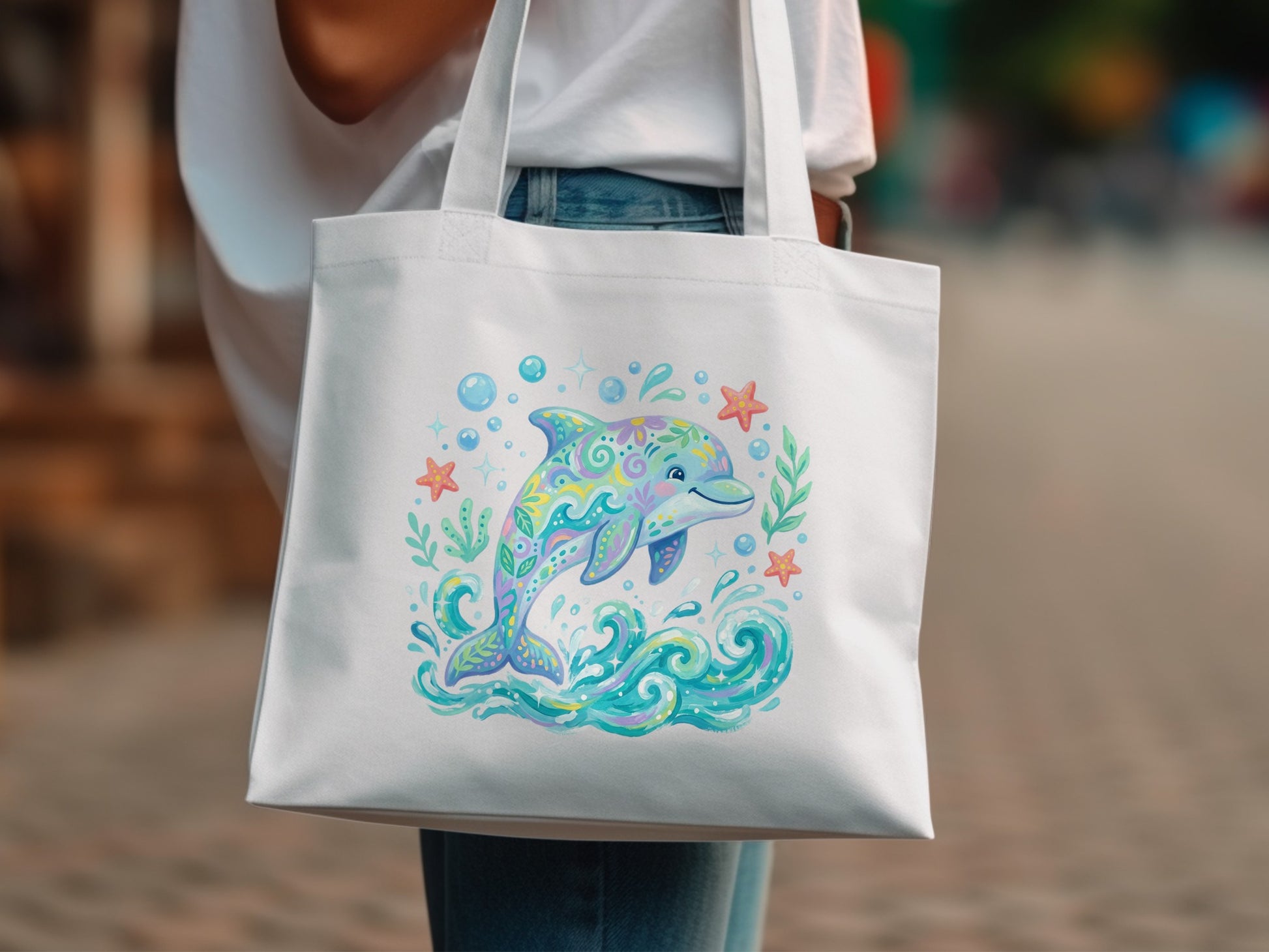 White tote bag with colorful cartoon dolphin, waves, and sea stars illustration.