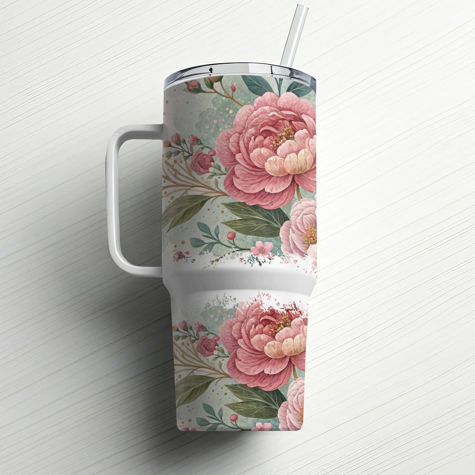 White tumbler with pink floral pattern and straw on a textured white surface.