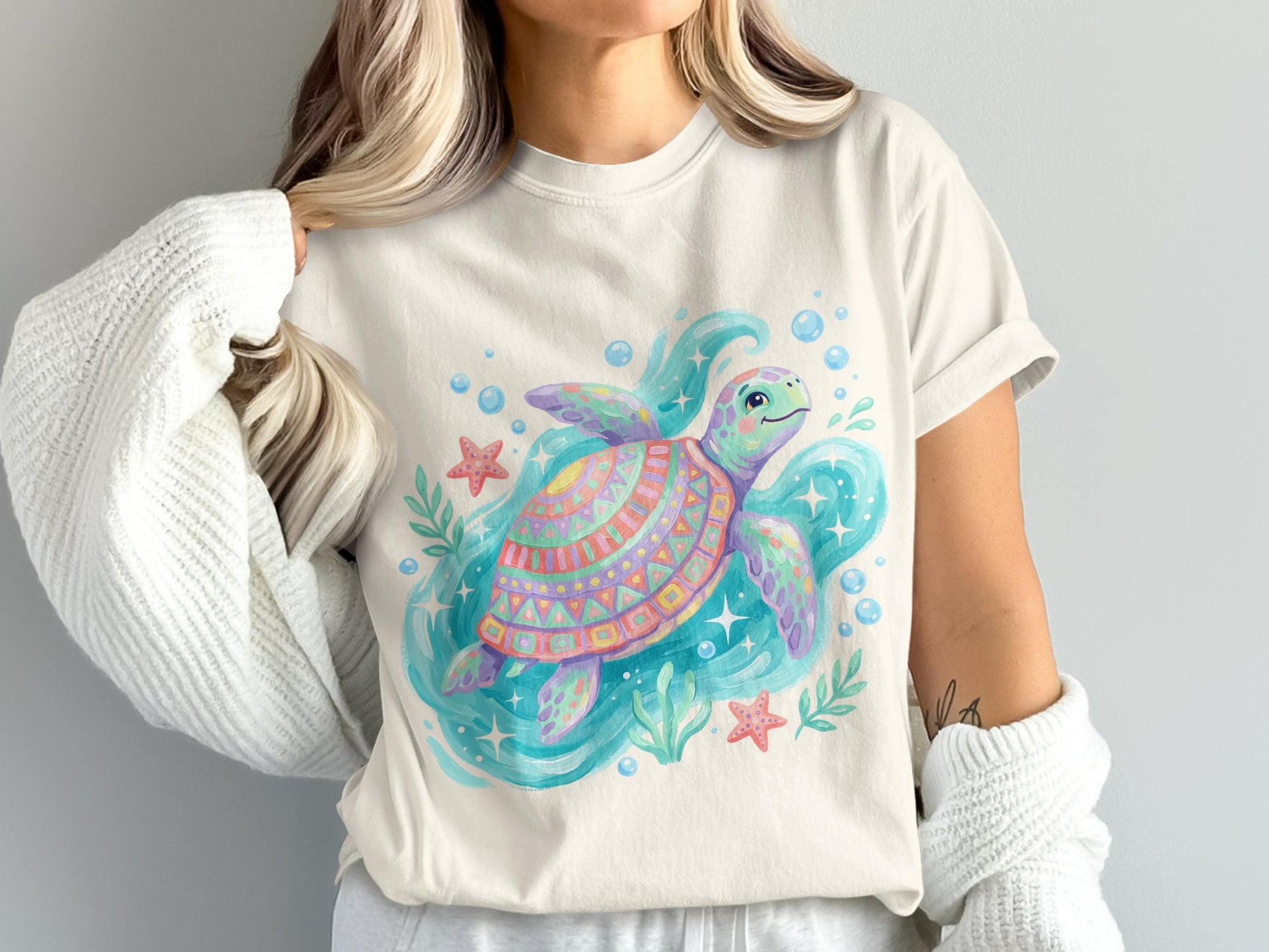 Colorful watercolor sea turtle with starfish and bubbles on a cream t-shirt.