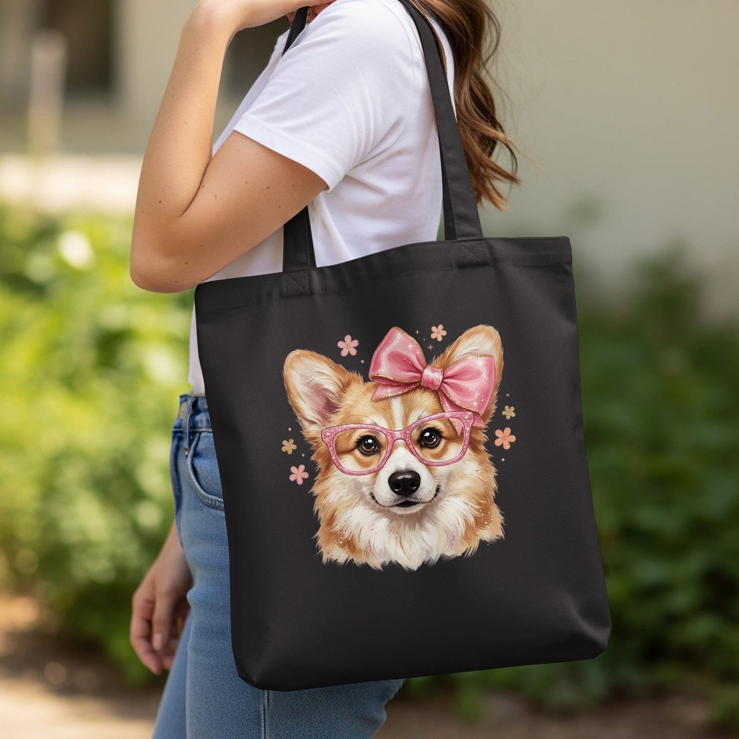Black tote bag with a corgi wearing glasses and a bow, surrounded by flowers.