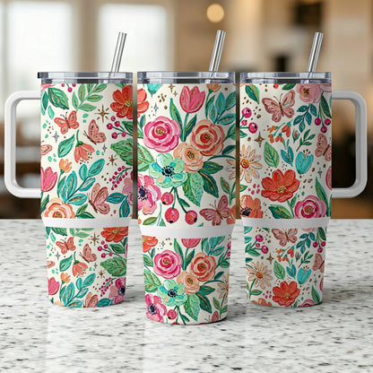 Three floral tumblers with straws and handles on a speckled countertop.