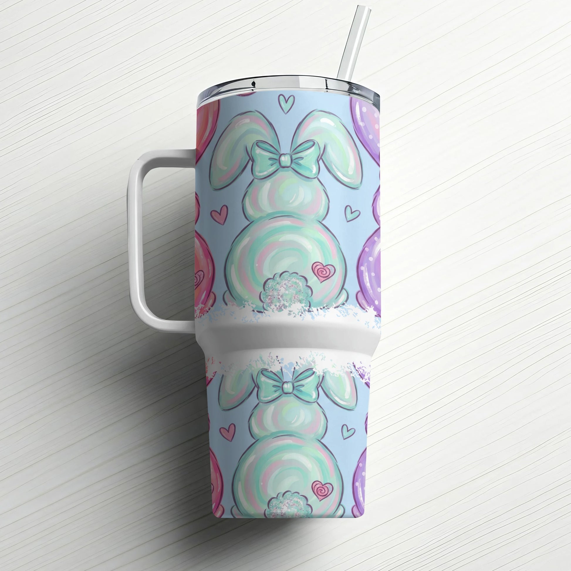 Easter bunny tumbler with pastel balloons and hearts on a white wooden background.