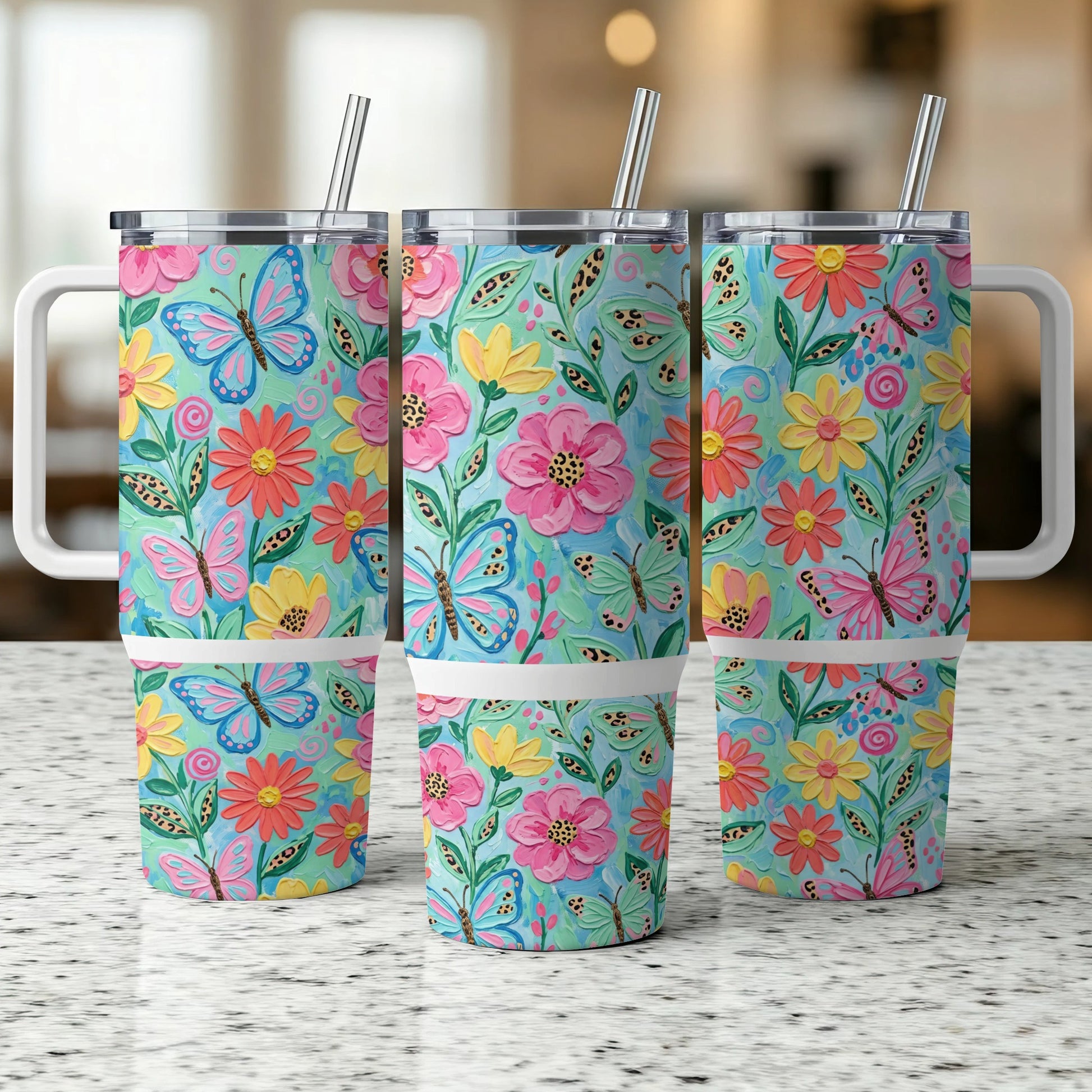 Three tumblers with butterfly and floral patterns, featuring straws.