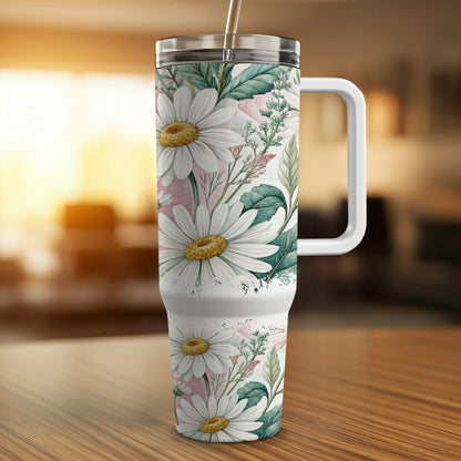 White floral tumbler with handle and straw on wooden surface.