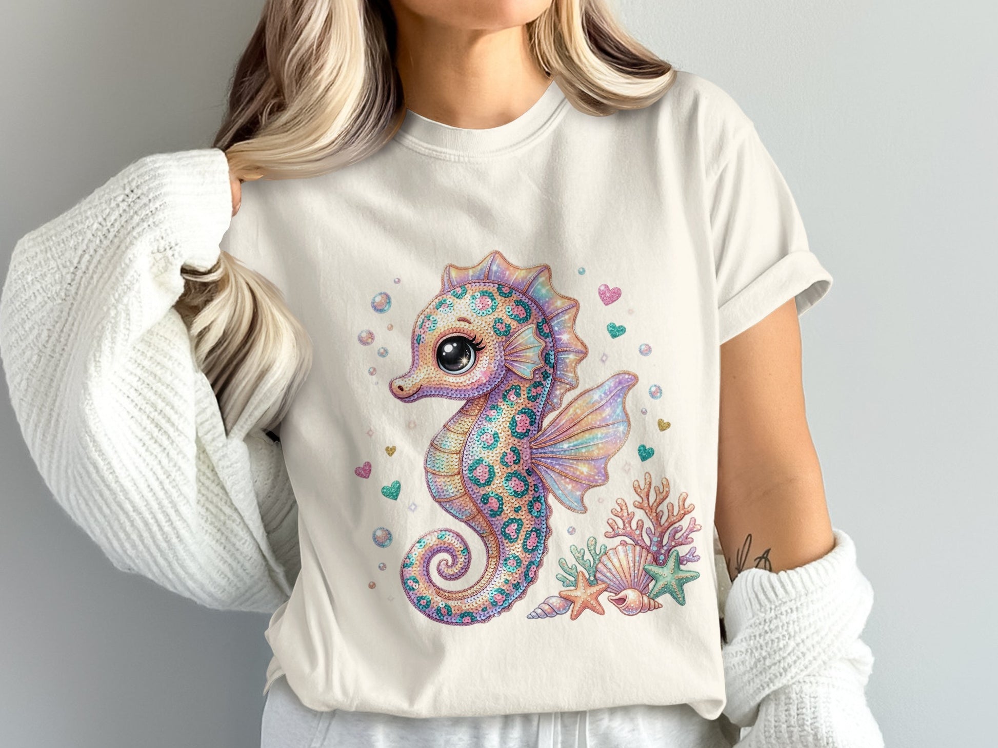 Cartoon seahorse with coral and seashells, surrounded by glitter hearts and bubbles.