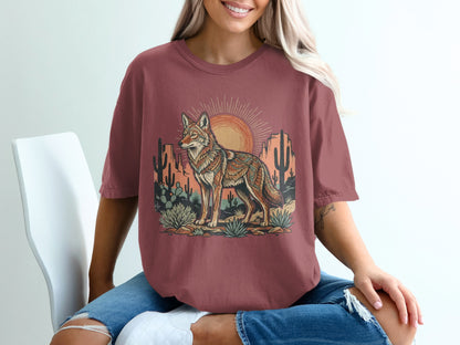 Crimson t-shirt with desert scene featuring a coyote, cacti, and sun.