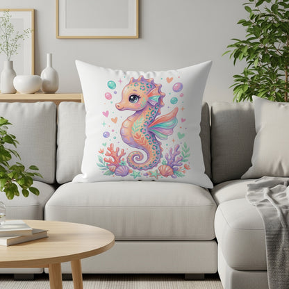 Pillow with whimsical seahorse, coral, and hearts on white couch.