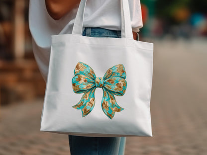 White tote bag with a large teal and gold textured bow design.