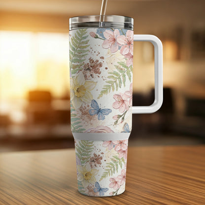 Floral and butterfly print tumbler with straw and handle.