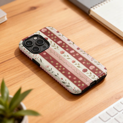 Phone case with a striped floral pattern on a wooden desk.