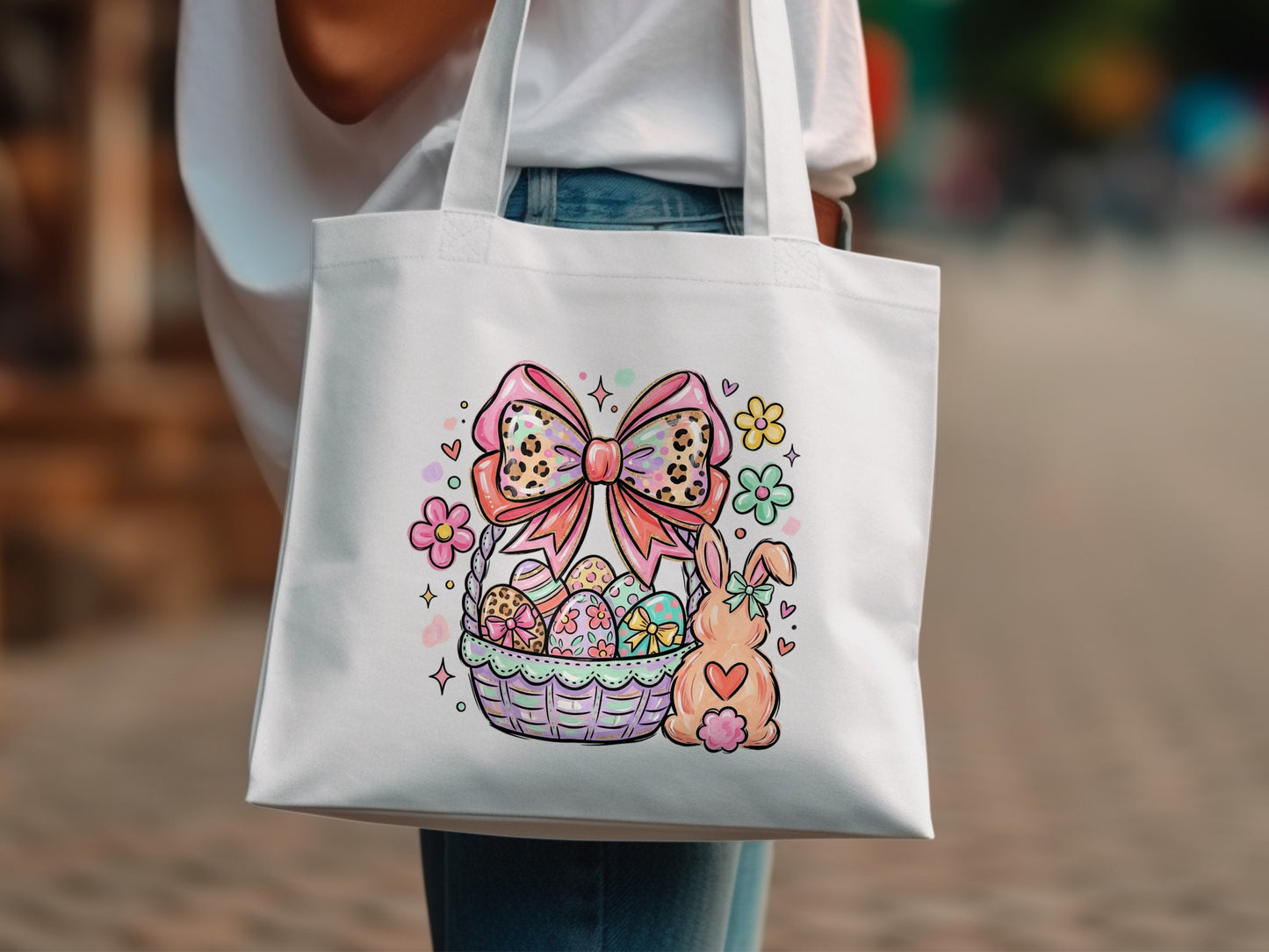 White tote bag with Easter basket, bunny, and flowers graphic.