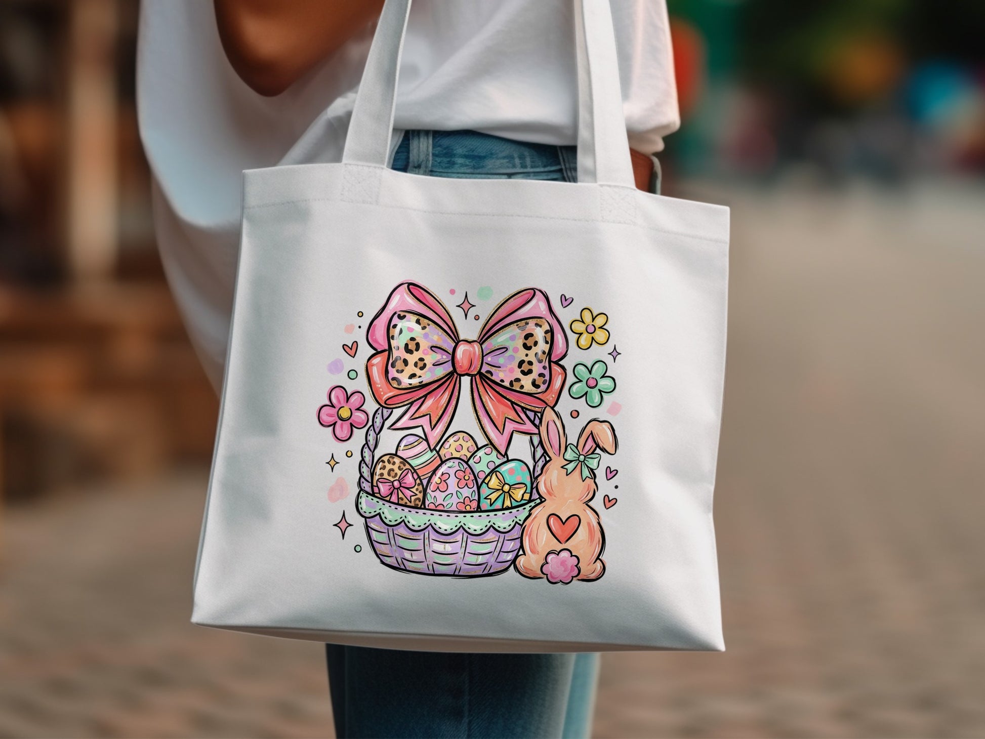 White tote bag with Easter basket, bunny, and flowers graphic.